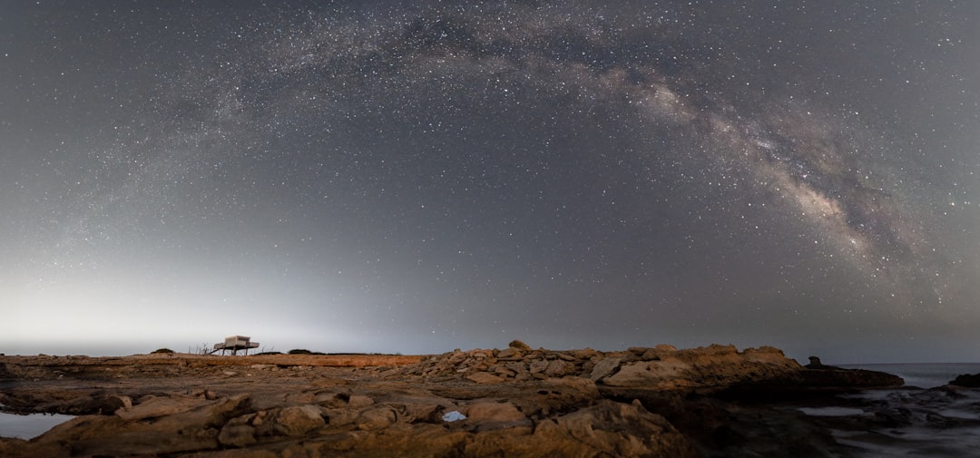 A view of the night sky from a rocky shore